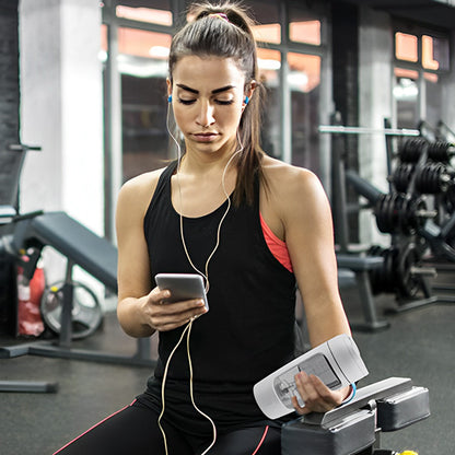 femme avec ecouteurs tient shaker proteine